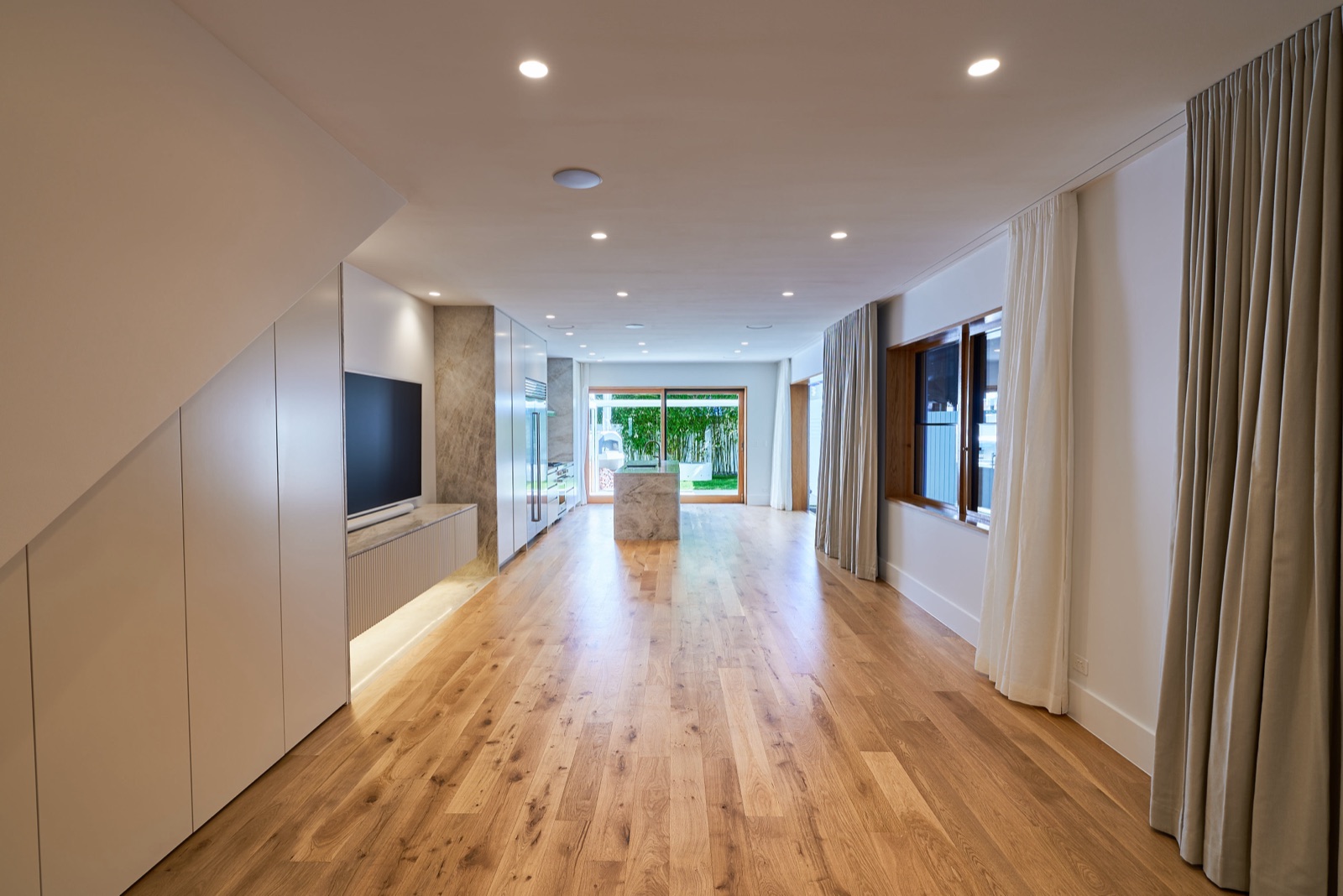 Living room with European oak floors by Perelli Group